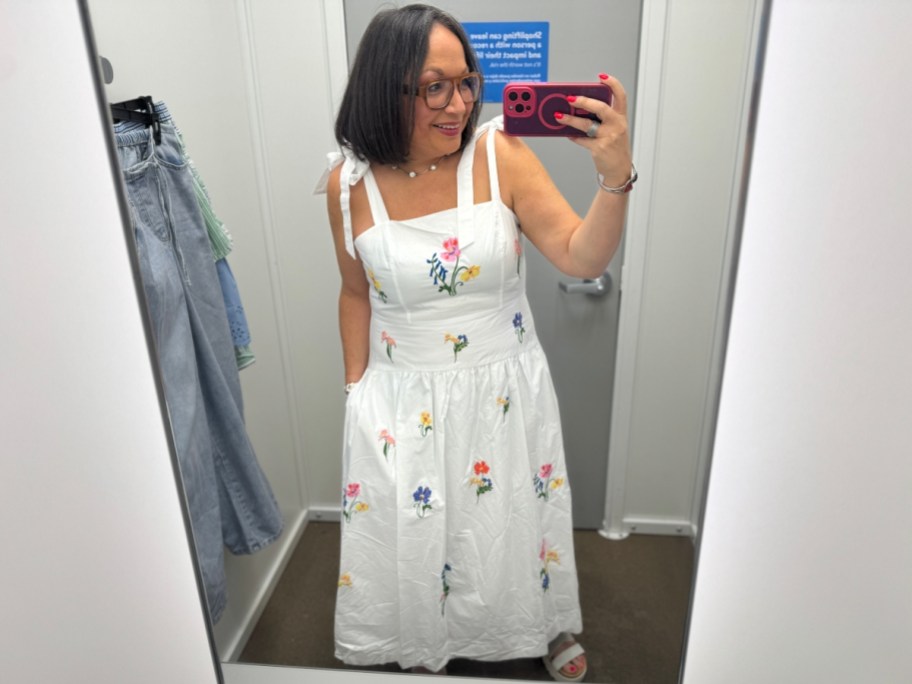 woman taking mirror selfie in white dress