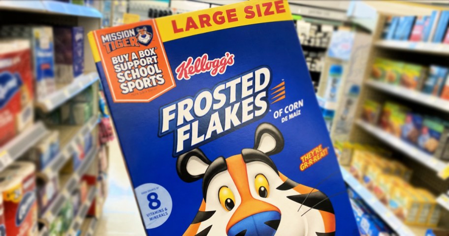 hand holding up a box of Frosted Flakes in store aisle