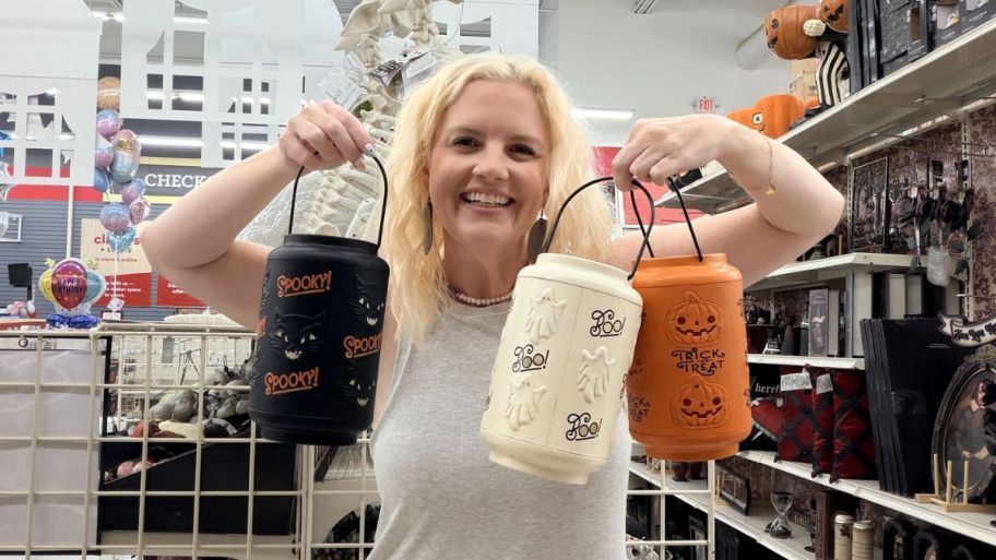 woman holding three different Halloween lanterns