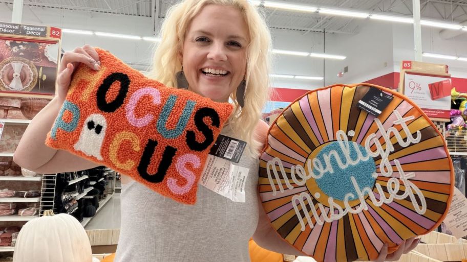 woman holding Hocus Pocus and larger throw pillow