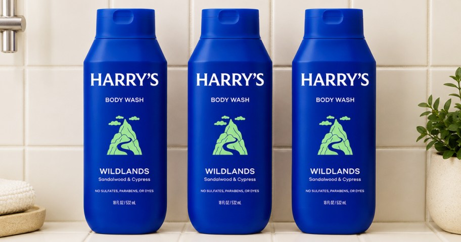 three blue bottles of Harry's body wash in a shower