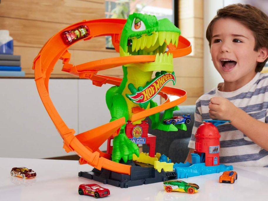 kid playing with Hot Wheels City T-Rex Blaze Battle Playset
