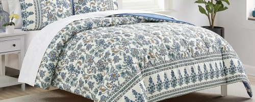 white and blue floral print comforter and shams on a bed