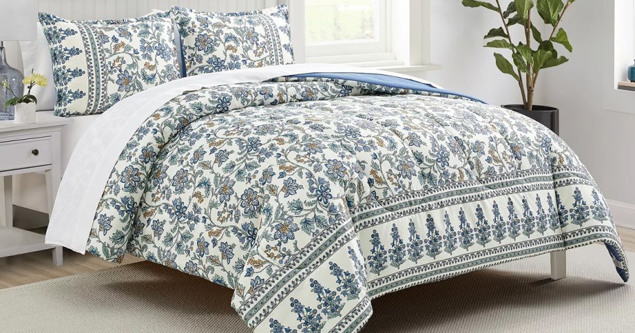 white and blue floral print comforter and shams on a bed