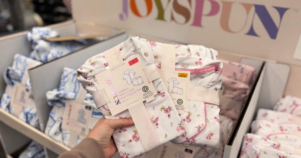 Hand holding up matching joyspun pajamas, inside Walmart store