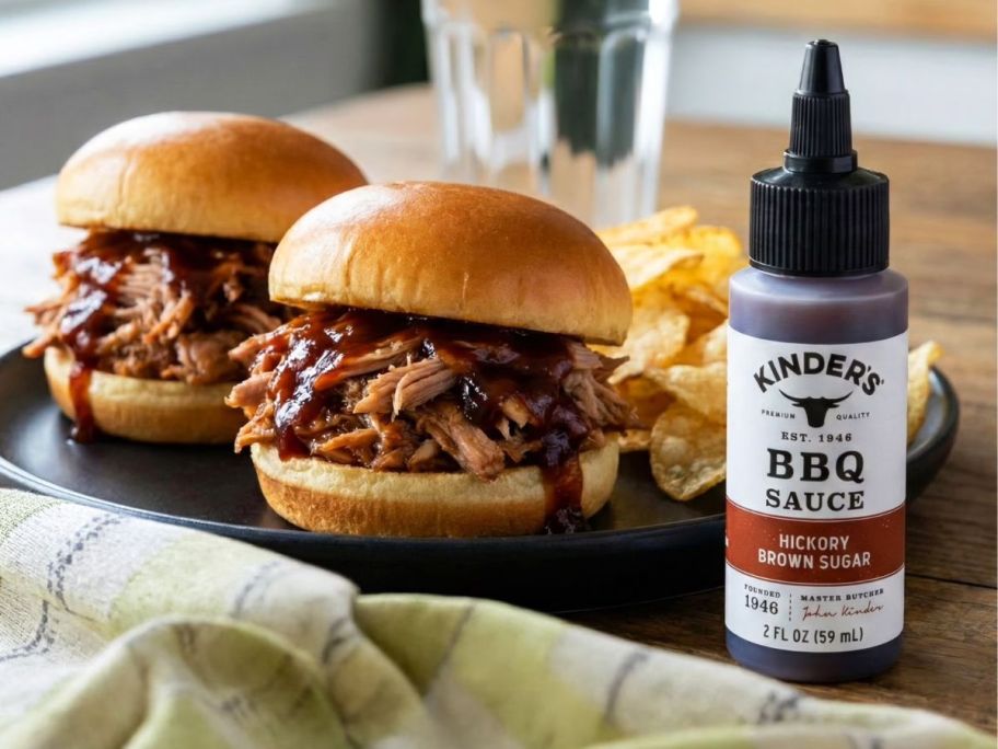 Kinder's Hickory Brown Sugar BBQ Sauce 2oz Bottle next to sandwiches