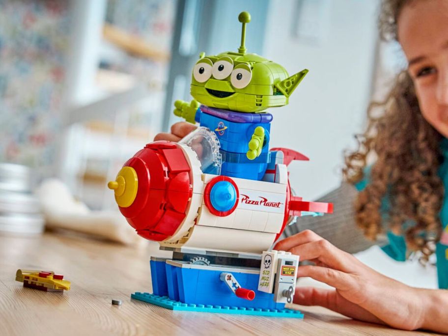 kid playing with LEGO Disney Alien w/ Pizza Planet Rocket Ride