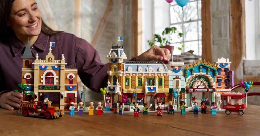 woman sitting next to LEGO Disney Main Street, U.S.A. set