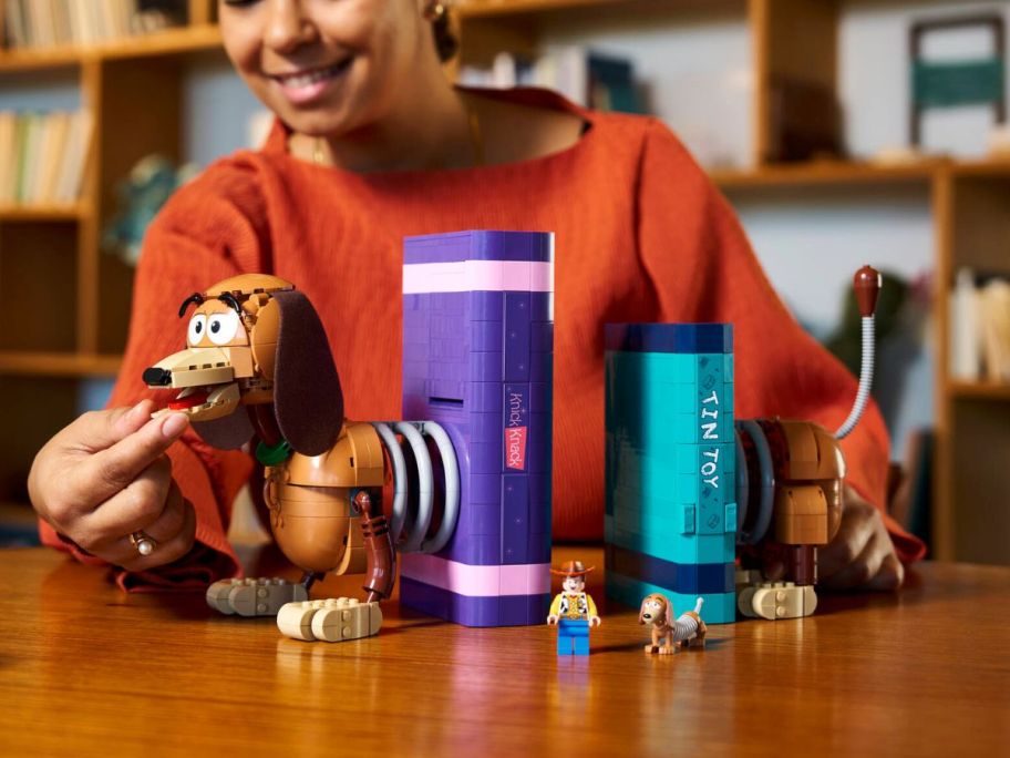 woman touching LEGO Disney & Pixar Toy Story Slinky Dog Bookends