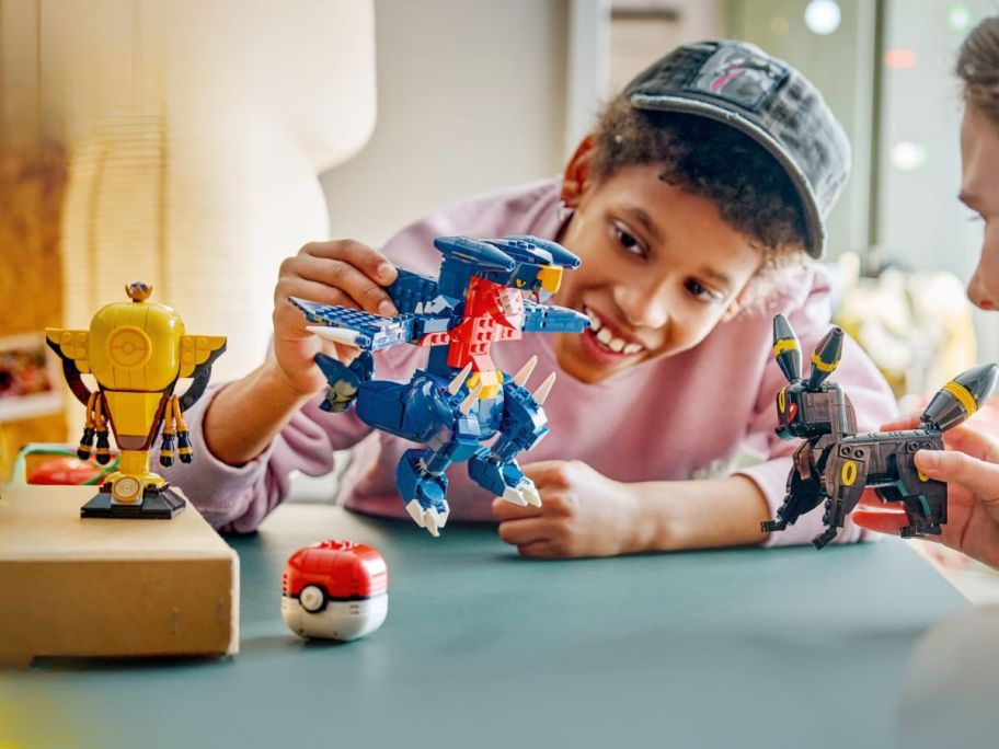 kid playing with LEGO Pokémon SMART Play: Umbreon vs Garchomp Championship Battle