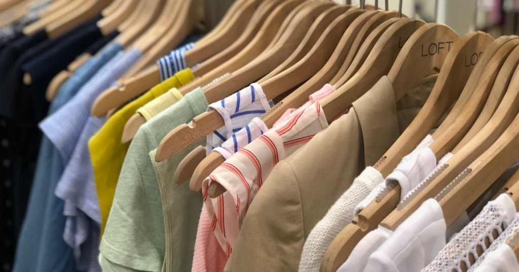 loft tops hanging on wooden hangers in store
