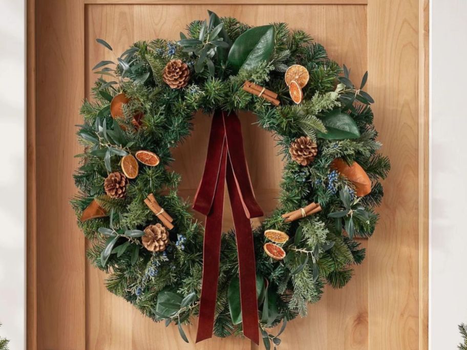 Large fall wreath with cinnamon sticks displayed on a door