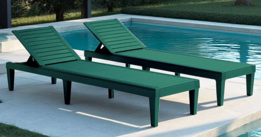 two green chaise lounge chairs near a pool