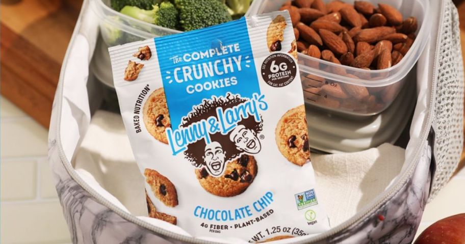 A lunch bag with broccoli, almonds and a bag of Lenny & Larry's Crunchy Chocolate Chip protein cookies
