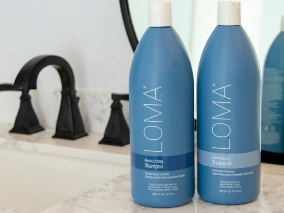 two liter bottles of Loma Moisturizing Shampoo and Conditioner next to a sink