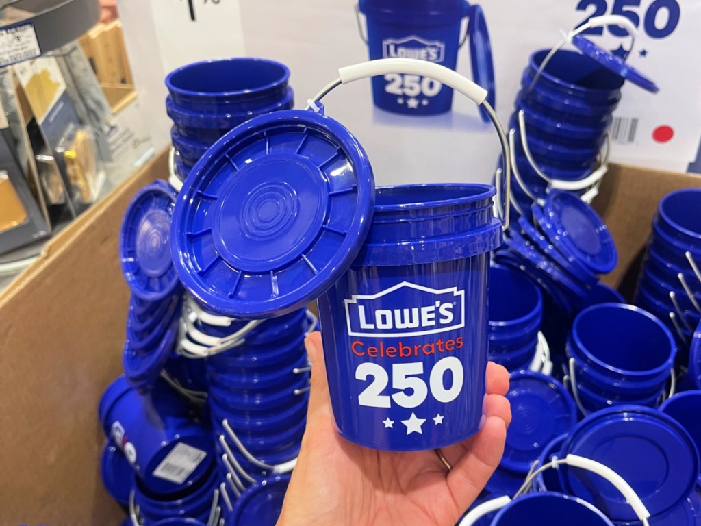 Hand holding up Lowe's patriotic bucket, inside store