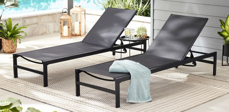 two black chaise lounge chairs on a patio