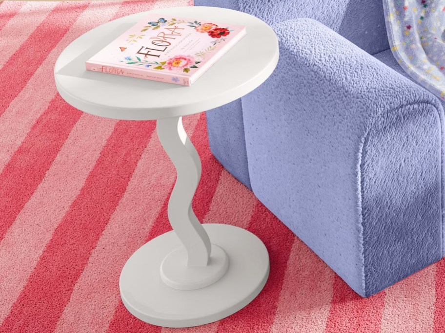 white wavy side table with a book on top