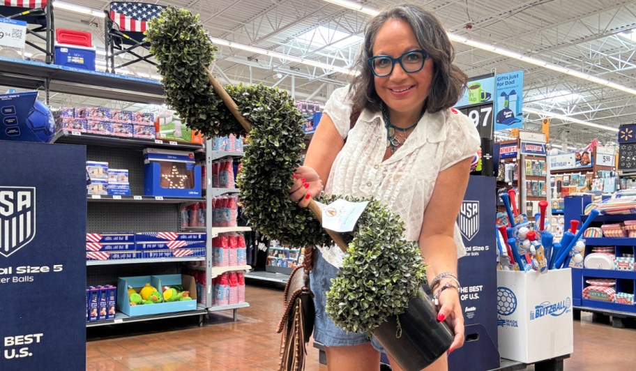 woman holding My Texas House Topiary in walmart