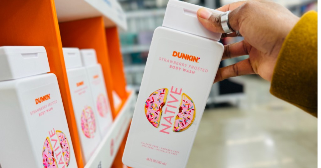 Hand holding bottle of native Dunkin body wash