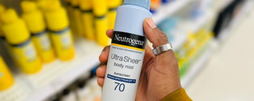 Hand holding bottle of Neutrogena sunscreen