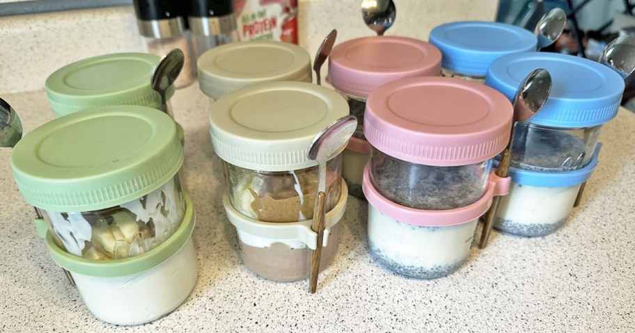 glass jars with layered yogurt inside with spoons