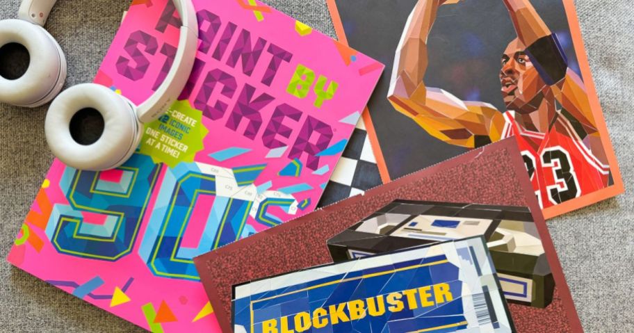 Paint By Sticker '90s Edition Book, headphones, and blockbuster, and michael jordan pages on table