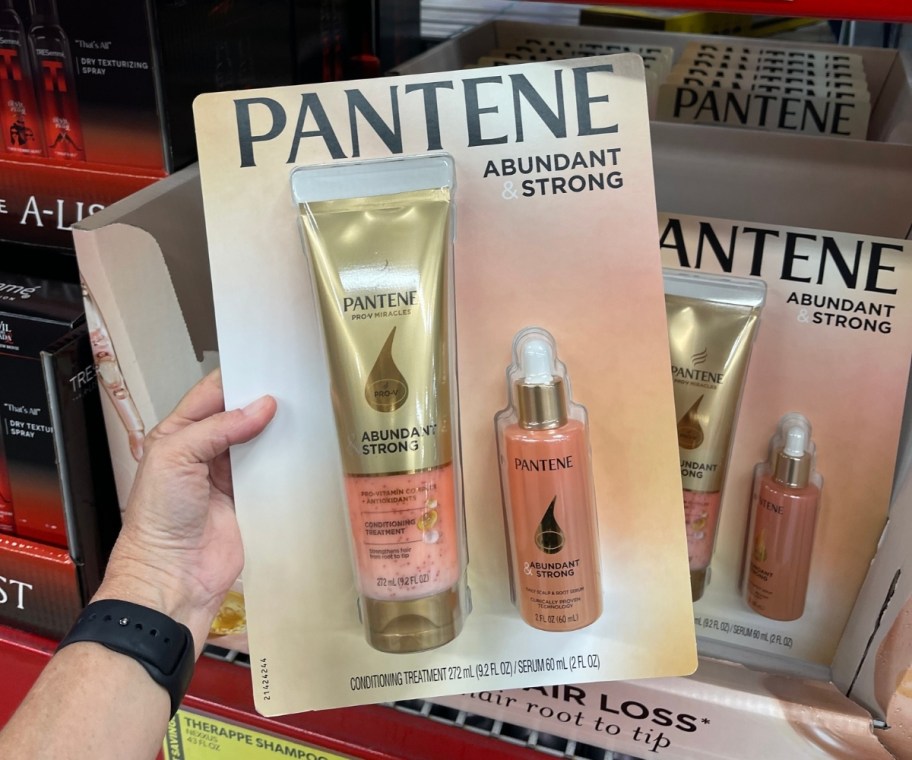 womans hand holding a package of Pantene Pro-V Miracles Abundant & Strong, Anti-Hair Loss Treatment + Serum 