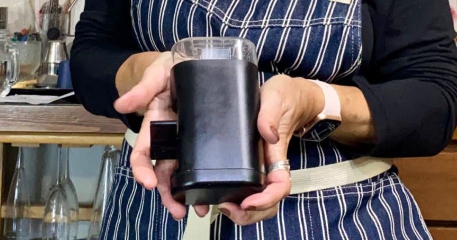 Woman holding a peppermate spice grinder