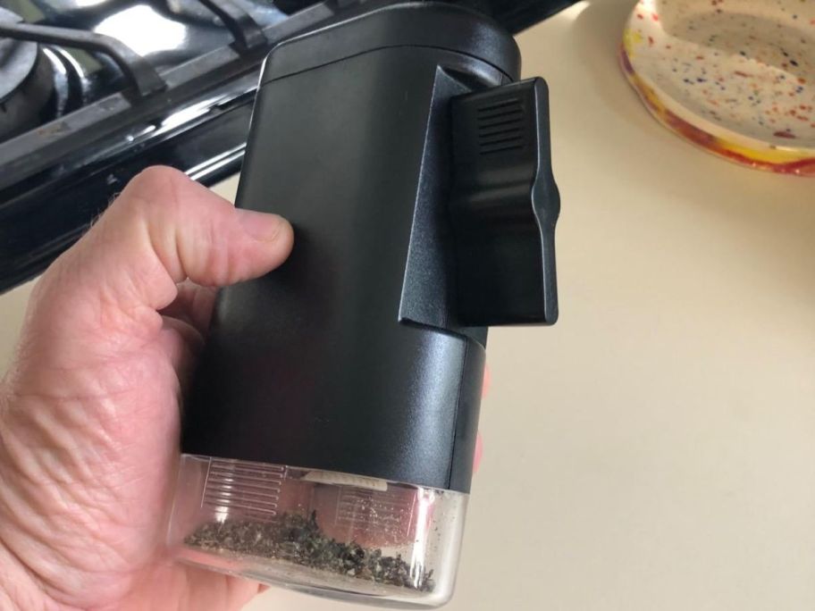 Hand holding a peppermate spice grinder