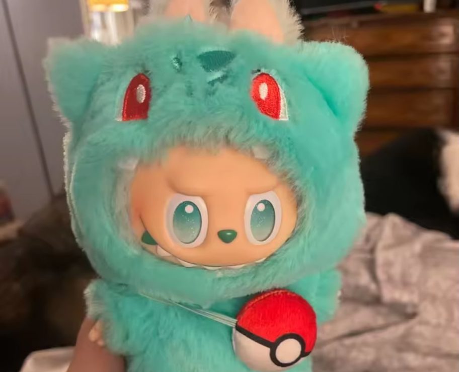 A labubu plush doll wearing a pokemon costume