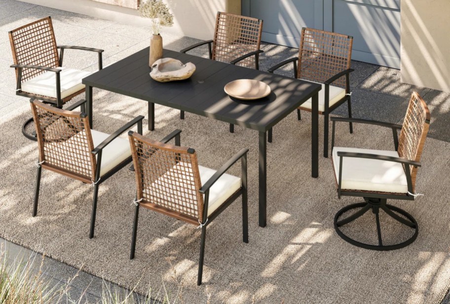 6 wicker patio chairs around a black dining table