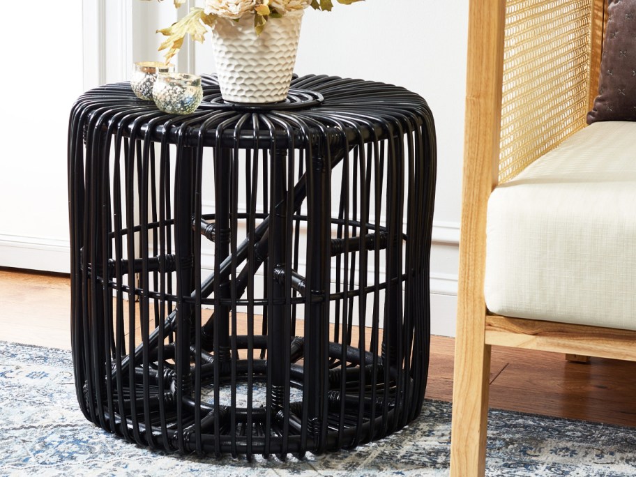 black round rattan end table near a chair