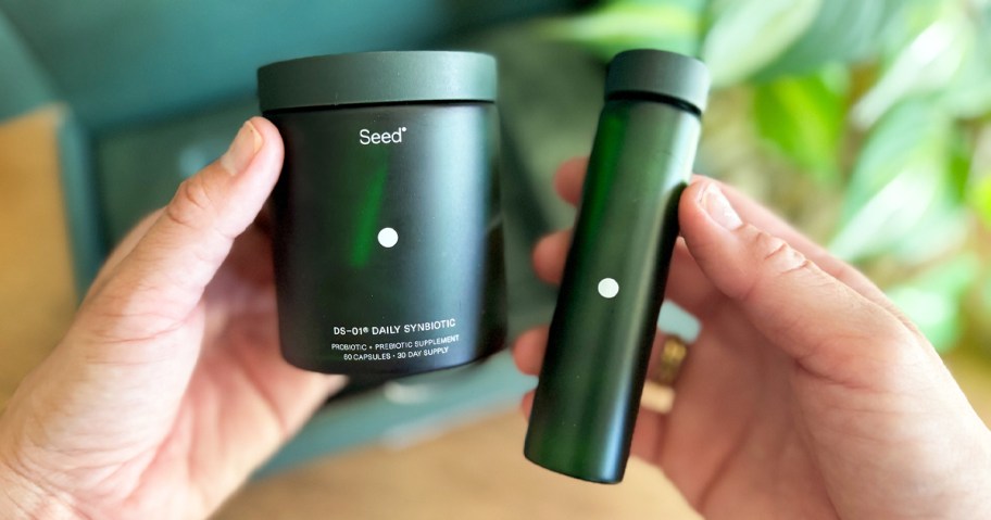hand holding a green jar and travel tube of probiotics