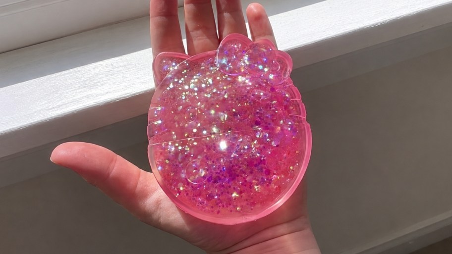 a hand holding a hello kitty slimy gloop gelli gel