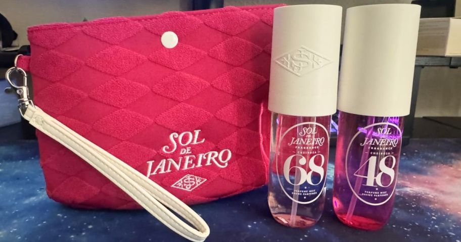 Two bottles of Sol de Janeiro Perfume Mists and a pink wristlet