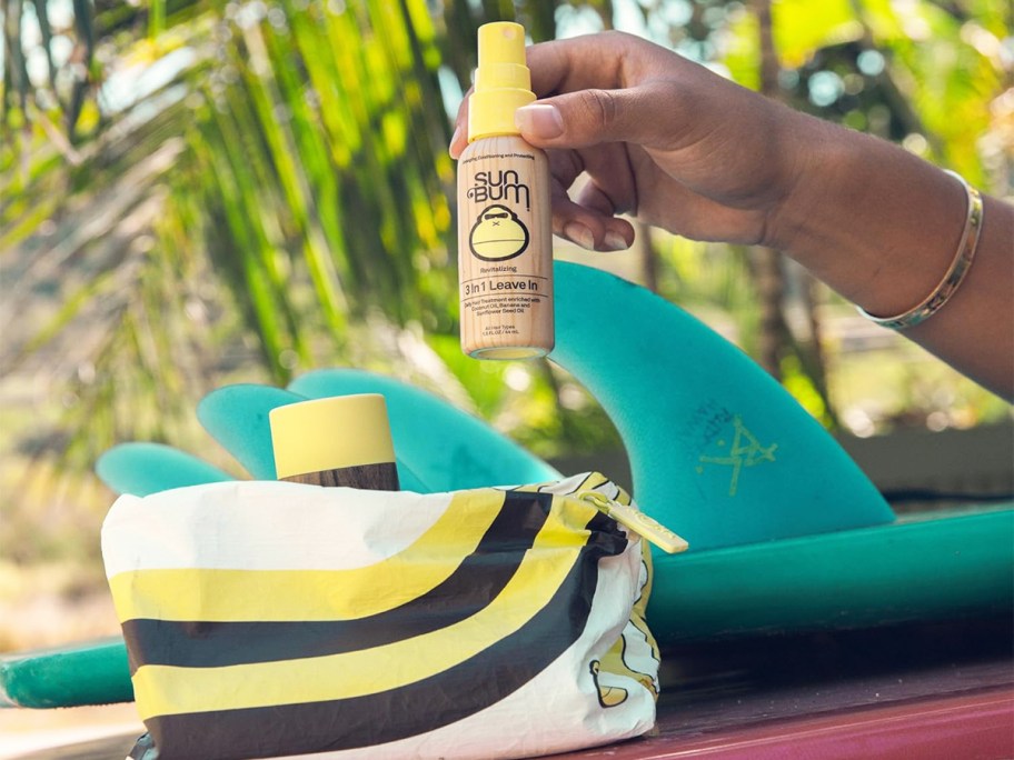 hand taking mini sun bum product out of cosmetics bag