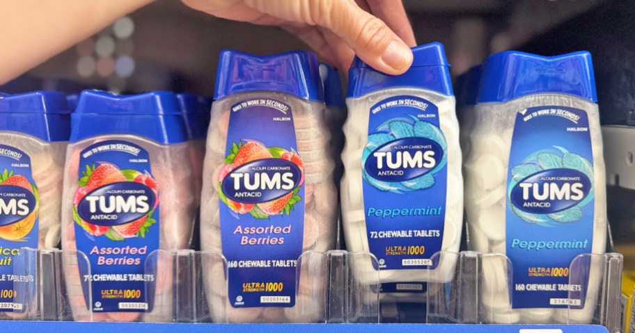 hand grabbing a bottle of tums from store shelf