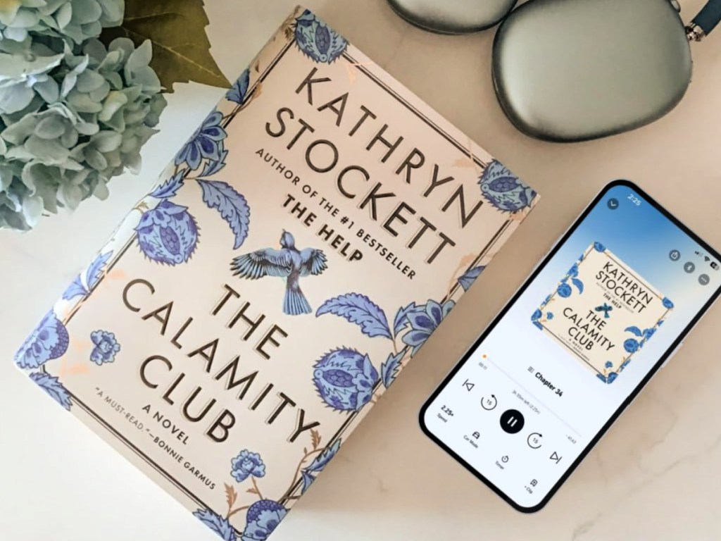 The calamity Club book on countertop next to Phone with Audible version
