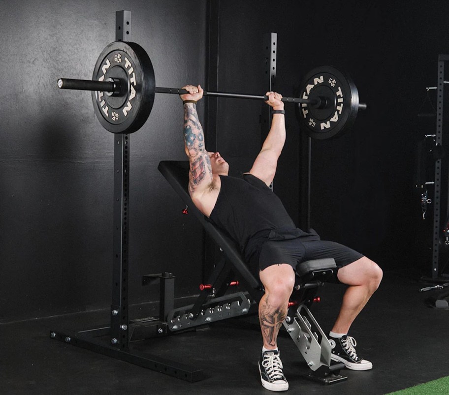 man on squat rack with weight bar