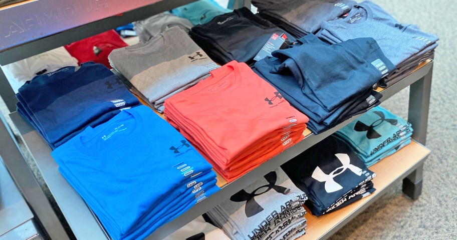 folded under armour shirts on store display table