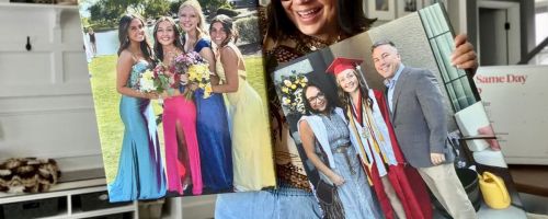 woman holding two Walgreens photo canvases with prom and graduation pics on them