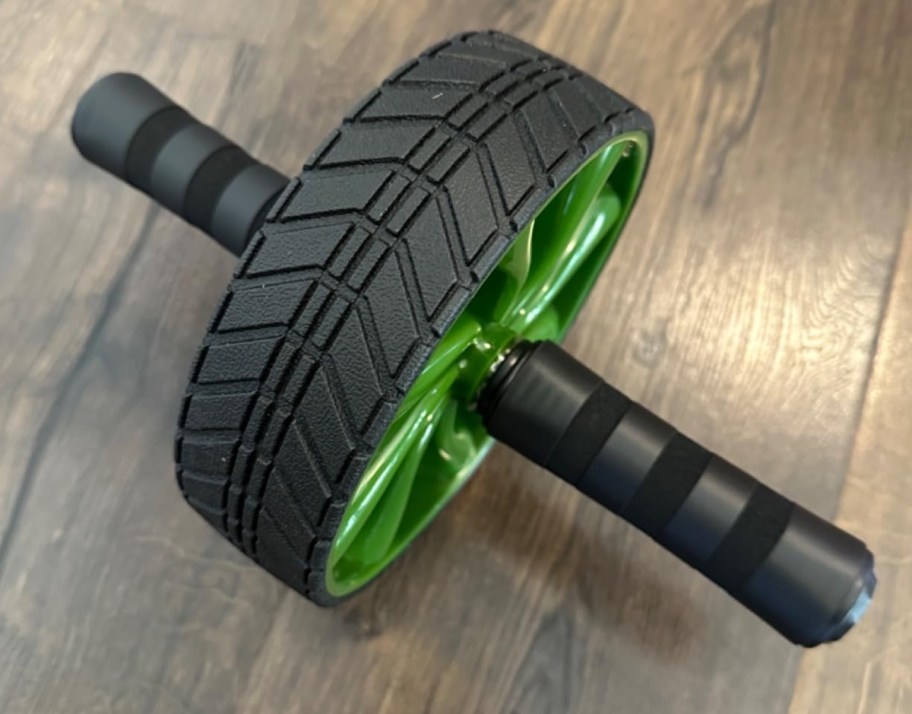 green and gray ab roller on wood floor