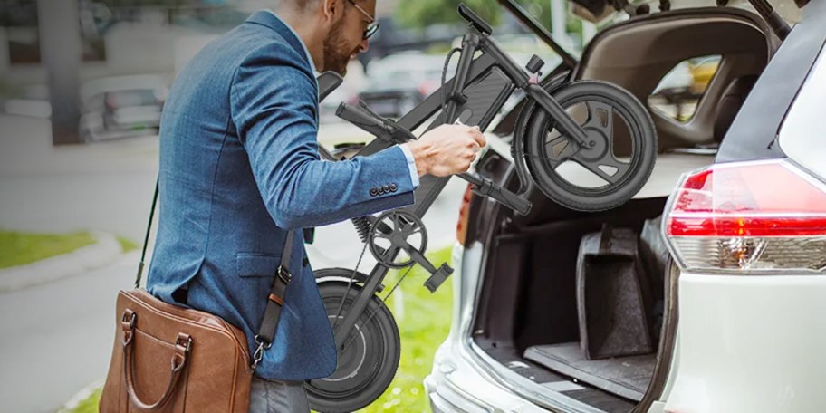 Man putting folded bicycle in trunk