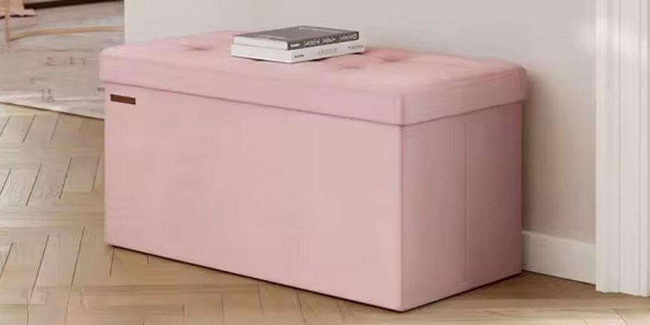 pink storage bnech with book on top 