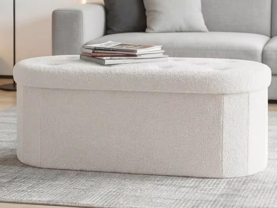 white ottoman with magazines on top 