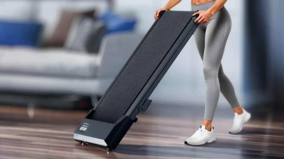 a woman rolling a treadmill out on two wheels