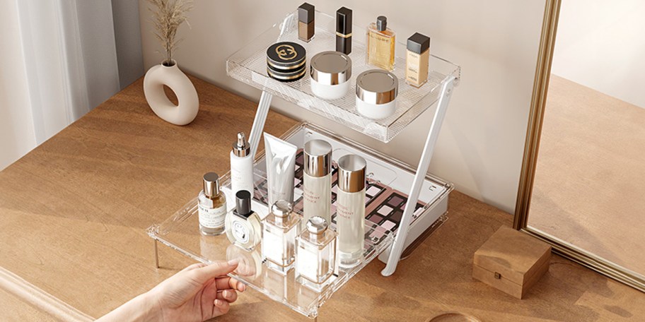clear bathroom organizer with drawer full of beauty products on table