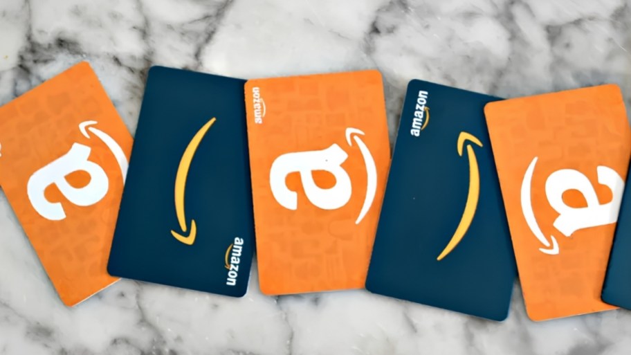 five amazon gift cards on a counter top