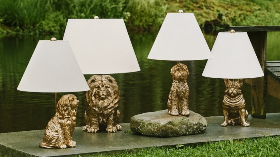 four variations of the icon dog table lamp arranged outdoors by a lake